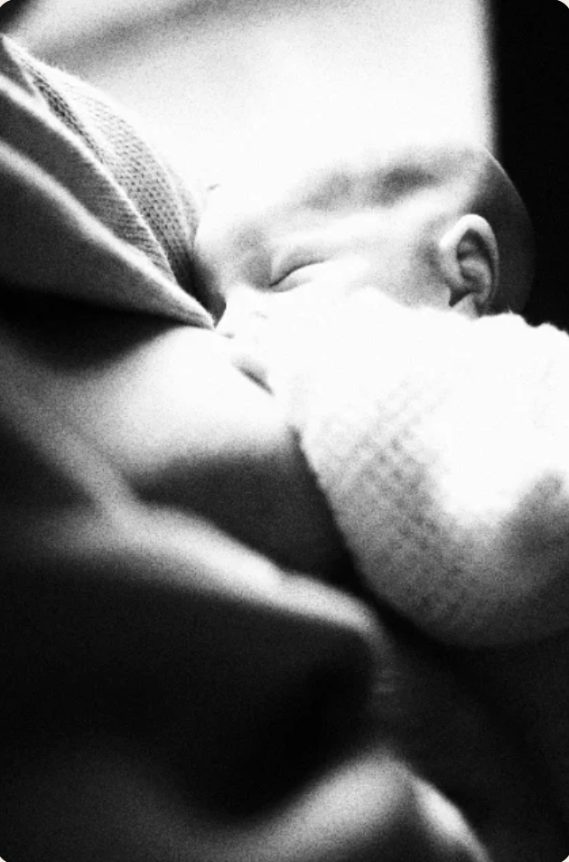 Newborn nursing, held close